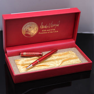 President Trump 2nd Term Executive Order pen in a red box with gold lining and signature, displayed on a black surface.