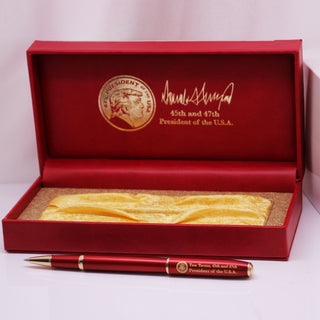 President Trump 2nd Term executive order pen in a red box with gold lining and signature, featuring a presidential seal.