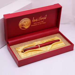 President Trump 2nd term executive order pen in a red box with gold accents and signature, displayed on a gold satin lining.