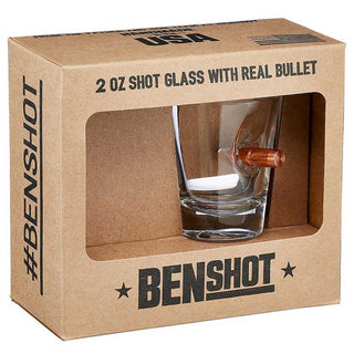 US flag shot glass with a real bullet embedded, displayed in a cardboard box labeled with product details.